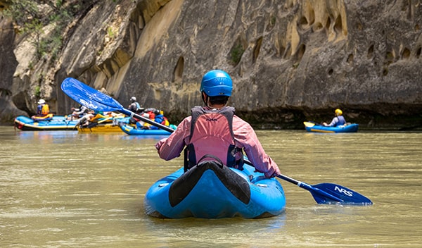Students in kayaks on a river with FLOW
