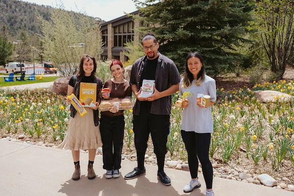 Students and staff hold food from the Grub Hub outside on campus.