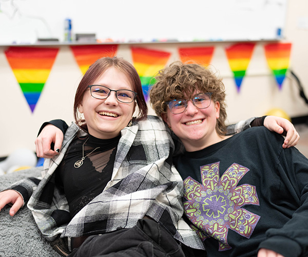 Students at the G, in front of pride flags